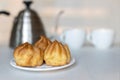 Homemade cakes profiteroles eclairs on a white saucer, background.