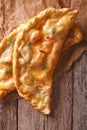 Homemade calzone close-up on a paper on the table. vertical top Royalty Free Stock Photo