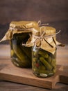 Homemade canning. Marinated cucumbers gherkins with dill and garlic in glass jar on the wooden table. Vegetable salads