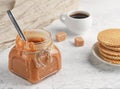 Homemade caramel sauce in a glass jar on a light table. Espresso in a white cup and fresh waffles. Close-up. Sweet dessert Royalty Free Stock Photo