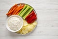 Homemade Caramelized Onion Dip with Potato Chips, Celery, Pepper and Carrot on a white wooden background, top view. Flat lay,