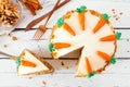 Homemade carrot cake with cream cheese frosting and slice being removed, above view table scene over white wood Royalty Free Stock Photo