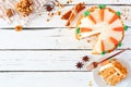 Carrot cake with cream cheese frosting, top view corner border with slice on plate over white wood Royalty Free Stock Photo