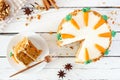 Carrot cake with cream cheese frosting, top view table scene with slice on plate over white wood Royalty Free Stock Photo