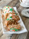 A carrot cake jelly roll on a platter, sliced into, ready for serving.