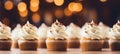 Homemade carrot cake muffins with cream cheese frosting on blurred background with copy space
