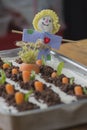 Homemade Carrot cake shaped as a carrot garden, decorated with a scarecrow doll Royalty Free Stock Photo