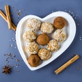 Homemade carrot energy protein balls with nuts, coconut flakes and raisins in heart shaped plate. Raw food desserts. Healthy Royalty Free Stock Photo