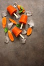 Homemade carrot popsicles with crushed ice and mint leaves on a dark rustic background. Vegan and vegetarian dessert. Frozen juice Royalty Free Stock Photo