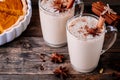 Homemade Chai Tea Latte with anise and cinnamon stick in glass mugs with pumpkin pie