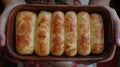 Homemade cheese rolls, kitchen setting, hands holding baking dish Royalty Free Stock Photo