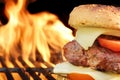 Homemade Cheeseburger Close-up On Flaming Barbecue Grill Background