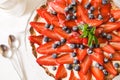 Homemade cheesecake decorated with organic strawberries, blueberries, fresh mint and cream. Nice pie for a holiday Royalty Free Stock Photo