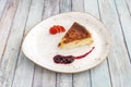 Homemade cheesecake with toasted surface, red berry jam and fresh raw strawberry slices on white plate Royalty Free Stock Photo