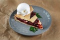 Homemade cherry cobbler pie with flaky crust, ice cream. 45 view, the plate is on craft paper. Royalty Free Stock Photo