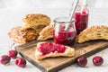 Homemade cherry jam, fresh cherries and cut lye rolls on a wooden board Royalty Free Stock Photo