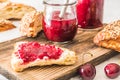 Homemade cherry jam on a lye roll on a wooden board Royalty Free Stock Photo