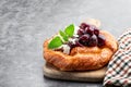 Homemade cherry puff pastry bun on gray background