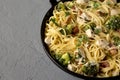 Homemade Chicken Bacon Broccoli Alfredo in a cast-iron pan on a gray surface, side view. Close-up Royalty Free Stock Photo