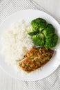 Homemade Chicken Breast, Rice and Broccoli on a white plate on a white wooden background, top view. Flat lay, overhead, from above Royalty Free Stock Photo