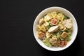 Homemade Chicken Caesar Pasta Salad in a white bowl on a black background, top view. Flat lay, overhead, from above. Space for Royalty Free Stock Photo