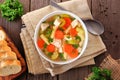 Homemade chicken noodle soup with vegetables, overhead table scene on wood Royalty Free Stock Photo