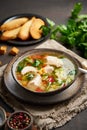 Homemade chicken soup with vegetables, broccoli on dark brown background, vertical, side view