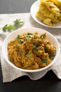 Homemade Chicken Tikka Masala in a white bowl on a black surface, side view. Flat lay, overhead, from above. Close-up Royalty Free Stock Photo