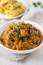 Homemade Chicken Tikka Masala in a white bowl on a white wooden background, low angle view. Close-up Royalty Free Stock Photo