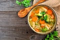 Homemade chicken vegetable soup, above view on rustic wood