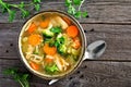 Homemade chicken vegetable soup, top view on rustic wood