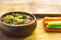 Homemade chickpea green hummus with herbs in round bamboo bowl, celery, carrot sticks on wood Royalty Free Stock Photo