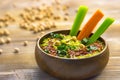 Homemade chickpea green hummus with herbs in round bamboo bowl, celery, carrot sticks on wood Royalty Free Stock Photo