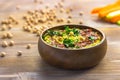 Homemade chickpea green hummus with herbs in round bamboo bowl, celery, carrot sticks on wood Royalty Free Stock Photo