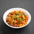 Homemade Chili Mac and Cheese with Parsley in a white bowl over black background, side view. Closeup Royalty Free Stock Photo