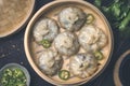 Homemade chinese and korean dumplings dim sum served on the traditional steamer bamboo box with soy sauce, parsley and chili peppe Royalty Free Stock Photo