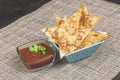 Homemade chips made from pita bread with cheese, herbs, spices and olive oil in turquoise square bowl and red dip sauce Royalty Free Stock Photo