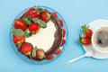 Homemade chocolate cake decorated with fresh strawberries on glass plate and cup of coffee with saucer Royalty Free Stock Photo