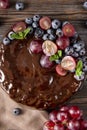 Homemade chocolate cake with fresh berries  grapes and blueberries, mint on a beige towel on a wooden brown background, berry pie Royalty Free Stock Photo