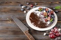 Chocolate cake with fresh berries, red grapes and blueberries, mint, coconut crumbs, powdered sugar and marshmallows on a white Royalty Free Stock Photo