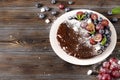 Homemade chocolate cake with fresh berries, red grapes and blueberries, mint, coconut crumbs, powdered sugar and marshmallows on a Royalty Free Stock Photo