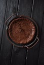 Homemade chocolate cake in vintage dish on black background low key copy space