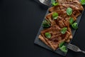 Homemade chocolate crepes served with blueberries, sauce and mint leaves on slate plate. Selective focus. Top view. Copy space Royalty Free Stock Photo