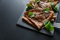 Homemade chocolate crepes served with blueberries, sauce and mint leaves on slate plate. Selective focus. Top view. Copy space Royalty Free Stock Photo