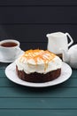 Homemade chocolate fruit cake with cream cheese and orange peel on dark blue background Royalty Free Stock Photo