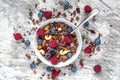 Homemade chocolate muesli or granola in a bowl with a spoon, berries, dried fruits and nuts