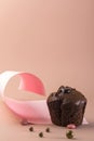 Homemade chocolate muffin on a pink background. Food geometric trend. Creative minimalist food design. Copy space. Vertical