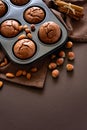 Homemade chocolate muffins brownies with cinnamon, almonds and hazelnuts on brown paper background Royalty Free Stock Photo