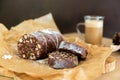 Homemade chocolate sausage on a wooden background. Dessert made of biscuits, chocolate and nuts is sliced on a wooden