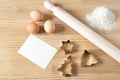 Homemade Christmas cookies. Blank greeting card or business card on wooden work table. Rolling pin, cookie cutters, eggs. Template Royalty Free Stock Photo